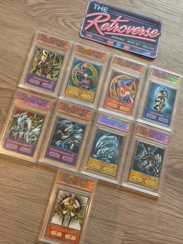A set of ten Yu-Gi-Oh! trading cards in protective plastic sleeves, arranged on a light brown wood floor, with a 'The Retroverse' brand sticker above them.