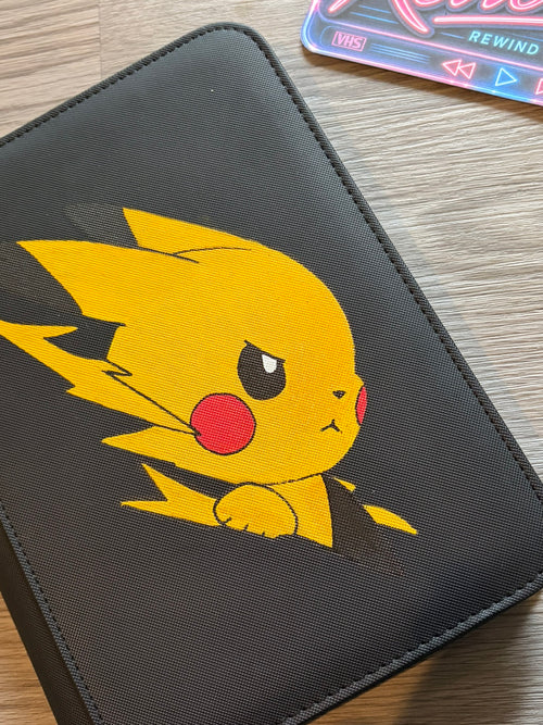 Hand-painted Pikachu artwork on the cover of a trading card binder.