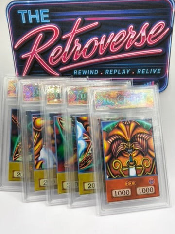 A set of Yu-Gi-Oh! trading cards sealed in clear plastic protective cases, displayed in front of a branded sign reading 'THE Retroverse' with the tagline 'REWIND . REPLAY .