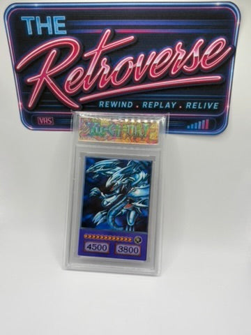 A Yu-Gi-Oh! trading card in a clear protective case, displayed in front of a colorful retro-style sign that reads 'The Retroverse' and 'Rewind Replay Relive'.