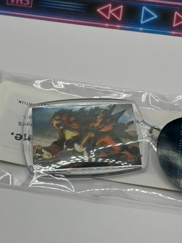 A Pokemon Entei Keyring  sealed in clear plastic packaging with a card behind it on a white surface.