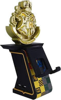 A gold and black Harry Potter Hogwarts crest phone stand on a white background. Harry Potter-themed gaming controller stand shown without a controller.