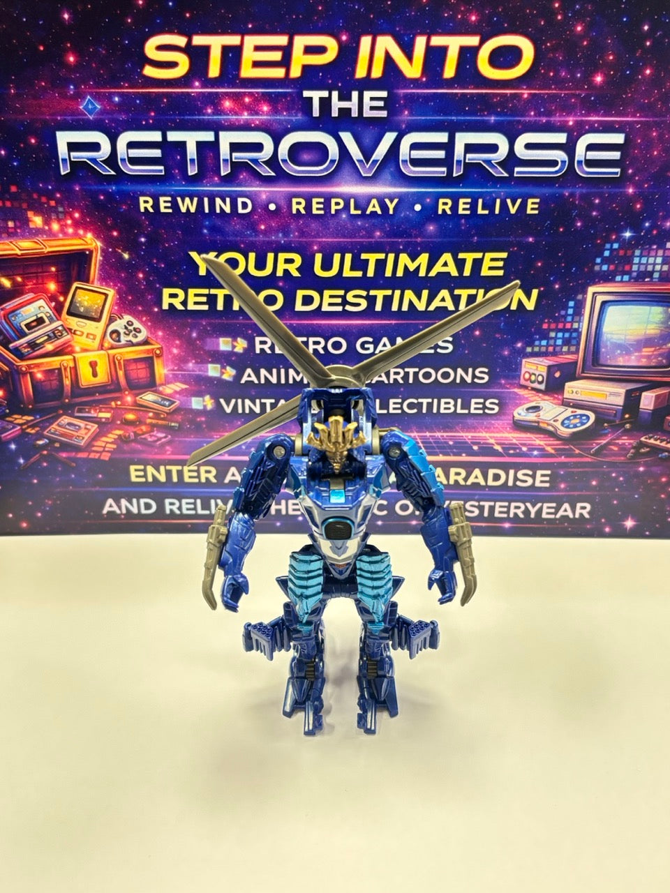 Toy robot figure in front of a promotional backdrop for 'Step into the Retroverse' with vintage technology imagery.