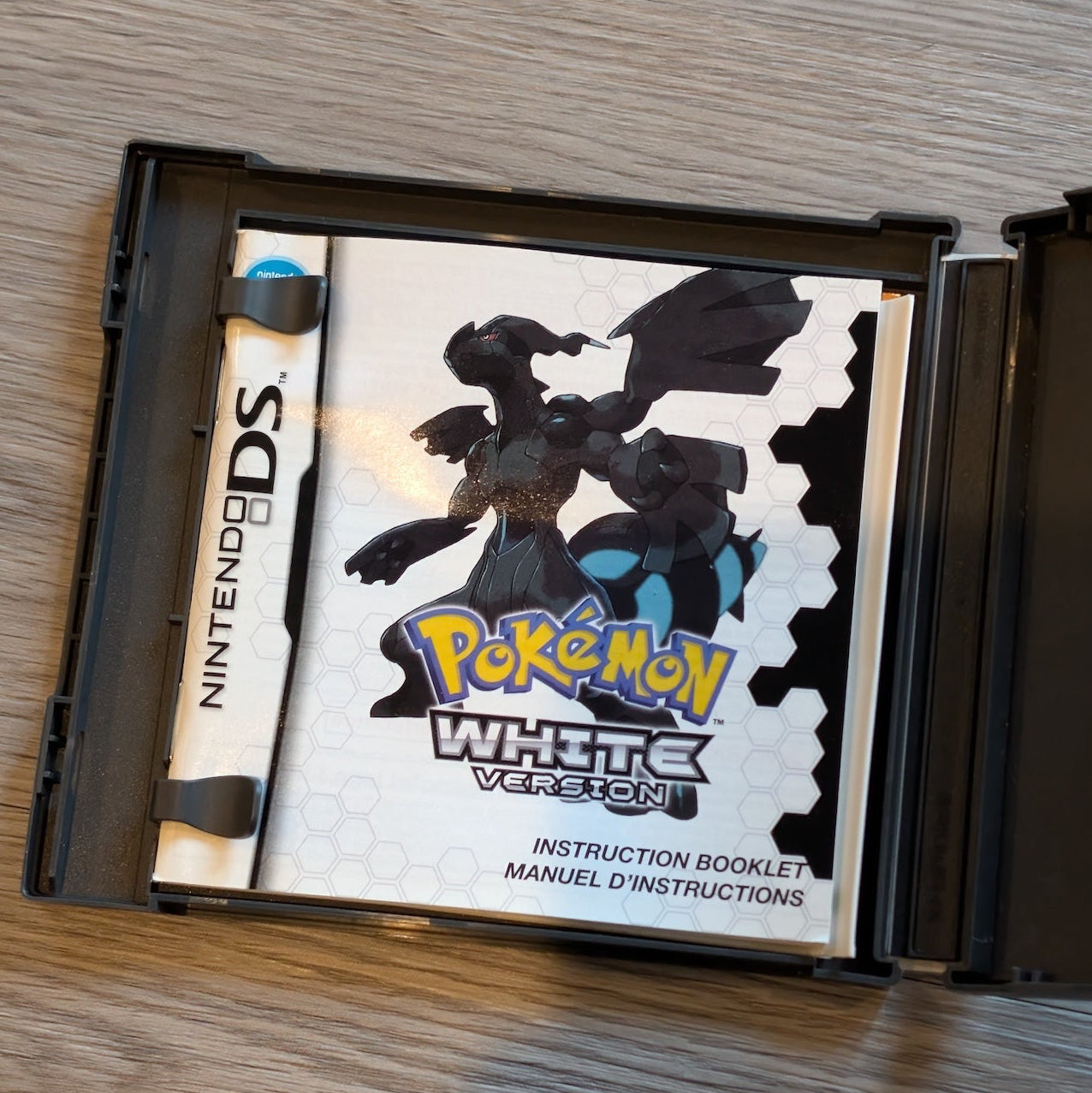 Nintendo DS game case with a Pokémon game on a wooden surface