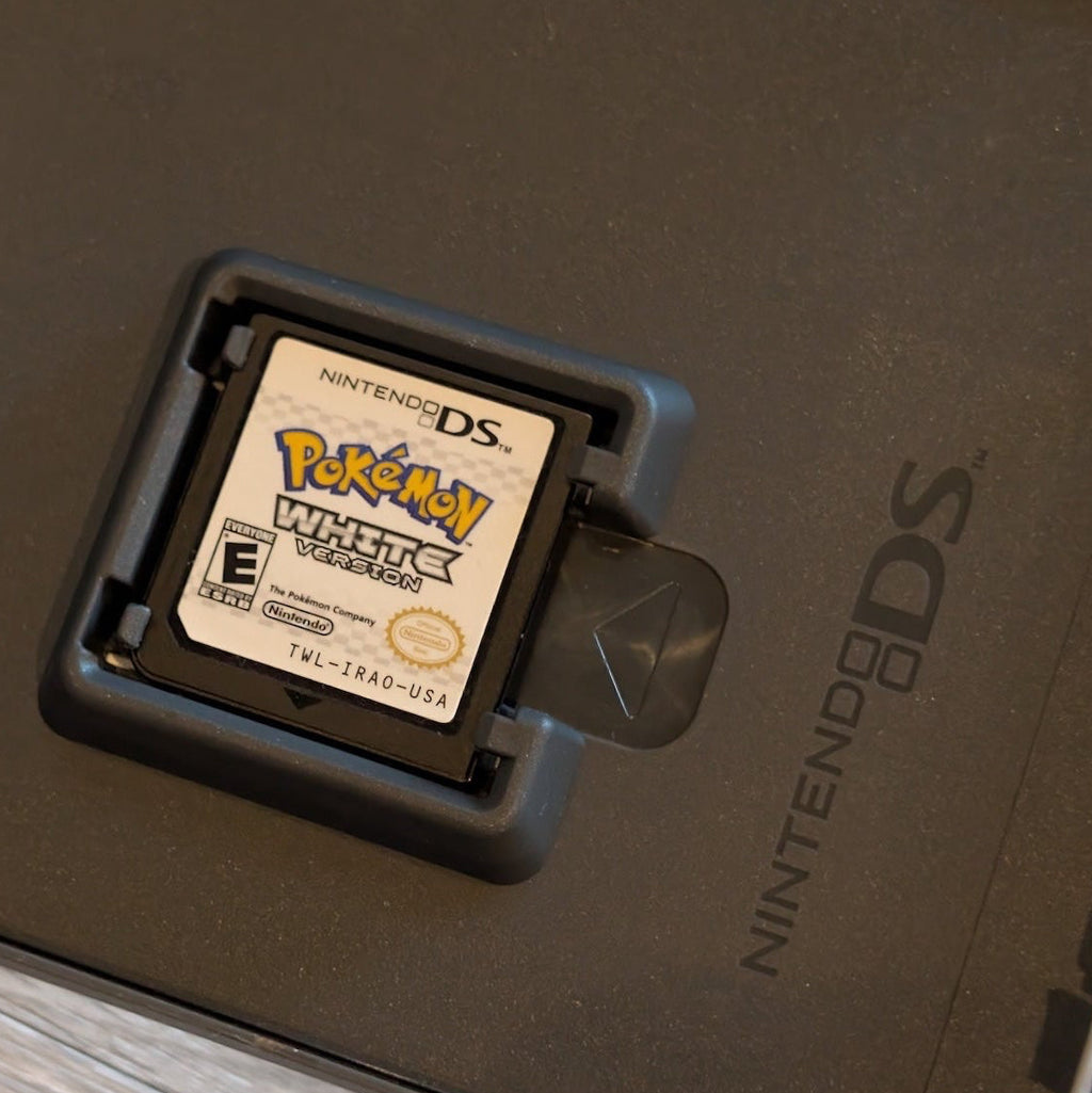 Nintendo DS Pokemon White game cartridge on a wooden surface